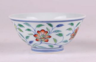 A Chinese Wucai style footed bowl decorated with flowering foliage, six character blue mark to the
