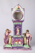 A Sunderland lustre pocket watch stand in the form of a longcase clock flanked by classical figures,