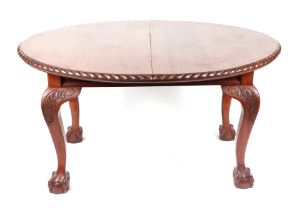 A late 19th century oval walnut extending dining table with cabriole legs terminating in ball & claw