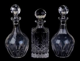 A pair of cut glass decanters, 28cms high; together with a square form decanter, 25cms high (3).