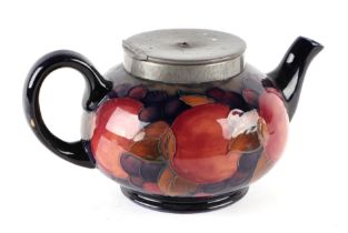 A Moorcroft pottery teapot with pewter cover decorated with fruit, 11cms high.