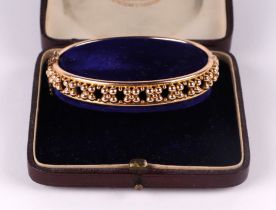 A Victorian yellow metal bangle with beaded granular decoration, 14g, 6.5cms diameter, presented