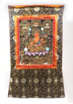 A Tibetan Thangka with central deity seated on a lotus flower, 45 by 60cms.