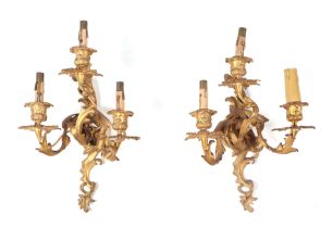 A pair of rococo style gilt brass three-branch wall lights, each approx 26cms wide (2). Condition