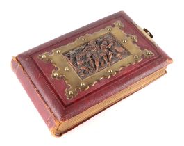 A Victorian leather carte de visite album with copper panel decorated with figures in relief