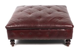 A large brown leather footstool on turned legs, approx 95cms square.