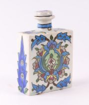 A Persian / Iznik pottery flask with traditional floral decoration, 11cms wide.