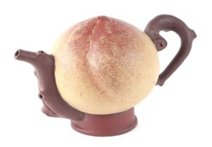 A Chinese Yixing pottery teapot in the form of a peach with crabstock handle, 11cms high.