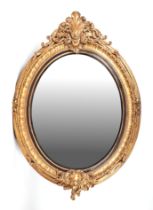 A large oval giltwood and gesso wall mirror, overall 106 by 153cms.