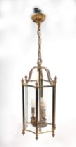 A brass and glass pendant hall lantern of hexagonal form, 55cms high.