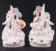 A pair of Staffordshire groups, 27cms high