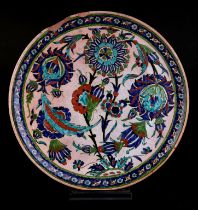 An Iznik / Palestine charger decorated with stylised flowers (a/f), 32cm diameter.