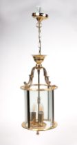 A brass and glass pendant hall lantern of cylindrical form, 51cms high.