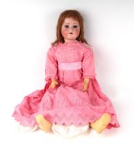 A Schoenau & Hoffmeister German bisque headed doll with sleeping blue eyes and open mouth, with