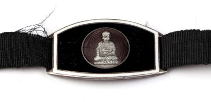 A white metal and enamel Siam panel on a ribbon bracelet.