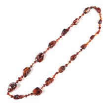 A reconstituted amber necklace, the larger beads in the form of human heads.