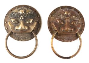 A pair of Asian cast brass handles in the form of temple dragons, each 20cms diameter (2).