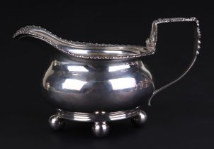 A George III silver cream jug, London 1815 and maker's mark for Robert Hennell, 8cms high, 211g.