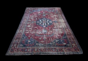 A large Persian carpet, the central blue medallion on a red ground within a repeating floral pattern