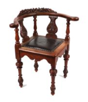 A 19th century oak corner chair, the crest rail carved with fruit and foliage.