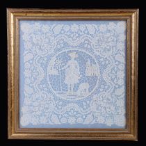 A 19th century lacework panel with central roundel depicting a girl with a lamb with buildings in