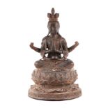 A large patinated metal multi-armed deity seated on a lotus flower, 38cms high.