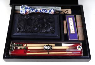 A Chinese calligraphy set to include an ink stone carved with a dragon, a famille rose porcelain