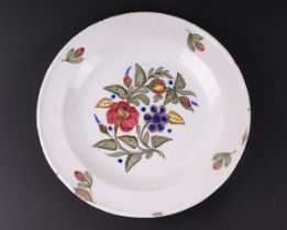 A Delft style tin glazed earthenware plate decorated with a spray of flowers, 34cms diameter.