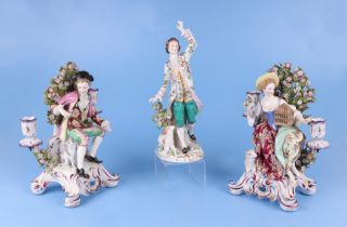 A pair of continental porcelain figural candlesticks depicting a young lady and gentleman seated