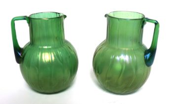 A Loetz style Neptune pattern green iridescent glass jug of globe and shaft form with angular