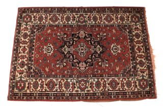 A small Persian rug with central medallion within a multi border, on a dark pink ground, 93 by