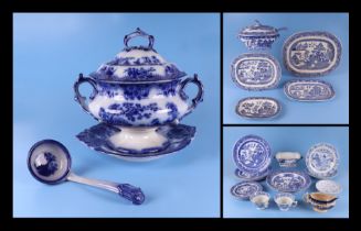 A quantity of assorted Willow pattern and blue & white dinner wares to include a flow blue
