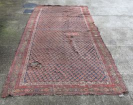 A large antique Persian rug with repeated stylised design within a multi border, 180 by 395cms.
