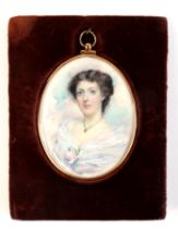 An early 20th century oval portrait miniature on ivory depicting a young lady wearing a gold