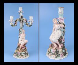 A pair of continental porcelain figural candelabra with flower encrusted decoration (one lacking