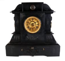 A Victorian black slate mantle clock of architectural form with applied female mask decoration,
