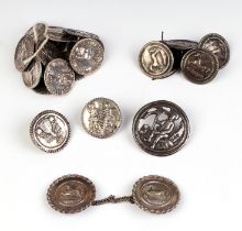 A quantity of 18th century Dutch white metal buttons and a cloak clasp, decorated with figures and