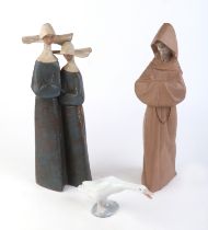 A Lladro group depicting two nuns, 31cms high; together with a Lladro figure of a monk, 34cms