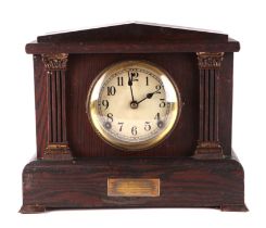 An Edwardian architectural oak mantle clock, having a white dial with arabic numerals fitted a eight