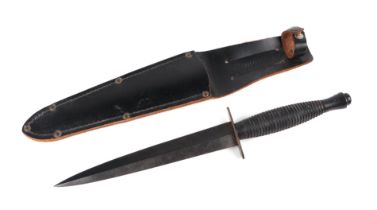 A Commando Knife by A. Wright in its leather scabbard. Marked to the crosspiece: A. WRIGHT & SON.