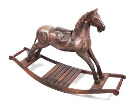 An antique style carved wooden rocking horse, overall 125cm long.