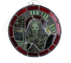 A 19th century stained glass roundel panel depicting a saint, 35cms diameter.
