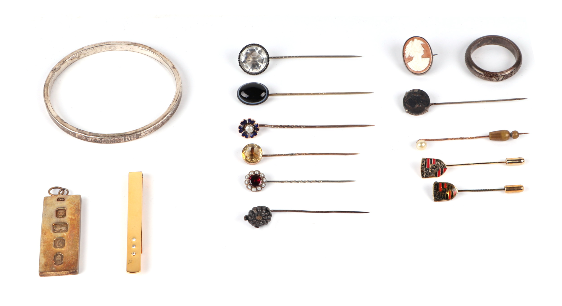 A group of stick pins to include enamel, agate and citrine; together with a silver gilt ingot