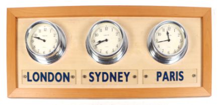 Three modern World time clocks, London, Sydney and Paris, mounted on a board.