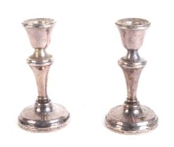 A pair of weighted silver candlesticks, 11cms high.