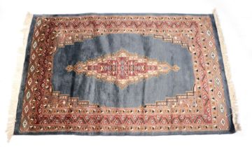 A Persian machine made rug with central medallion within a multi border, on a blue ground, 99 by