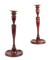 A pair of carved mahogany candlesticks with brass sconces, 32cms high (2).