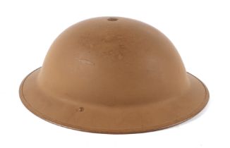 A WWII Brodie type steel British Army helmet in desert beige.