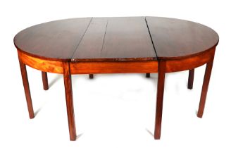 A George III style mahogany D-end dining table with reeded legs, inset with three extra leaves.