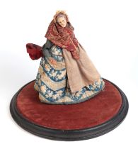 A terracotta Pedlar Doll figure depicting an old lady, signed to the underside, on an ebonised and